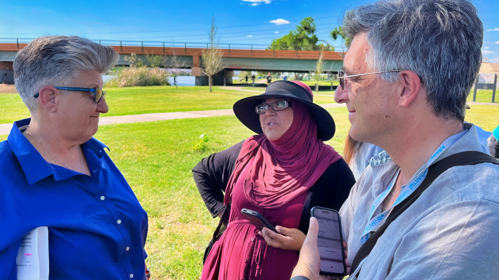 Carrie Hamblen, Daisy Maldonado and Algernon D’Ammassa speak on the grass at La Llorona Park after a press conference.