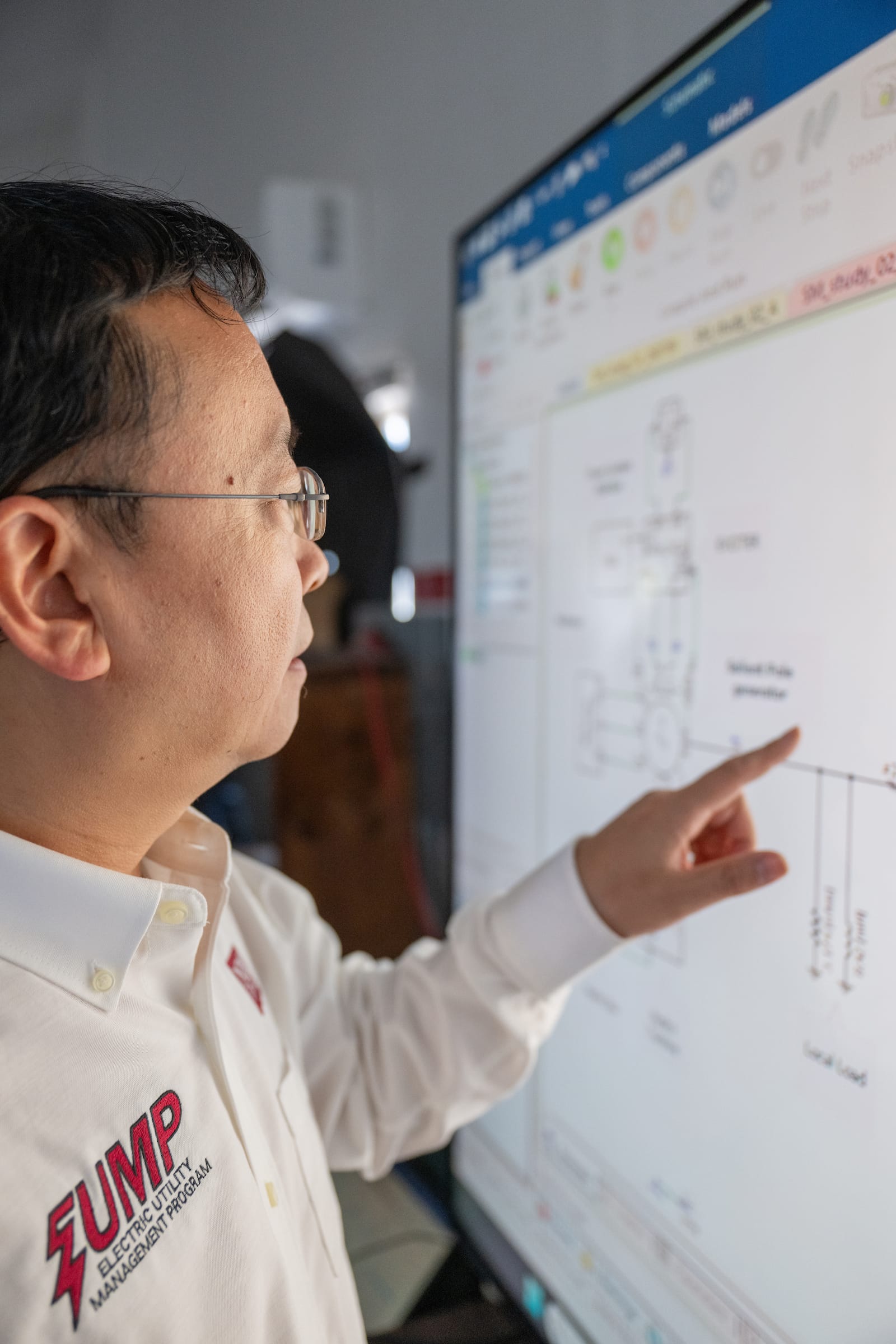 Man standing next to a screen with diagrams.