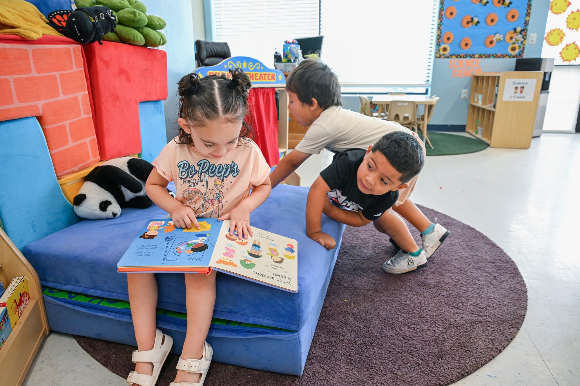 NMSU Head Start students Armani Villa, Mateo Chavarria and Perseus Walker read and play in a classroom.