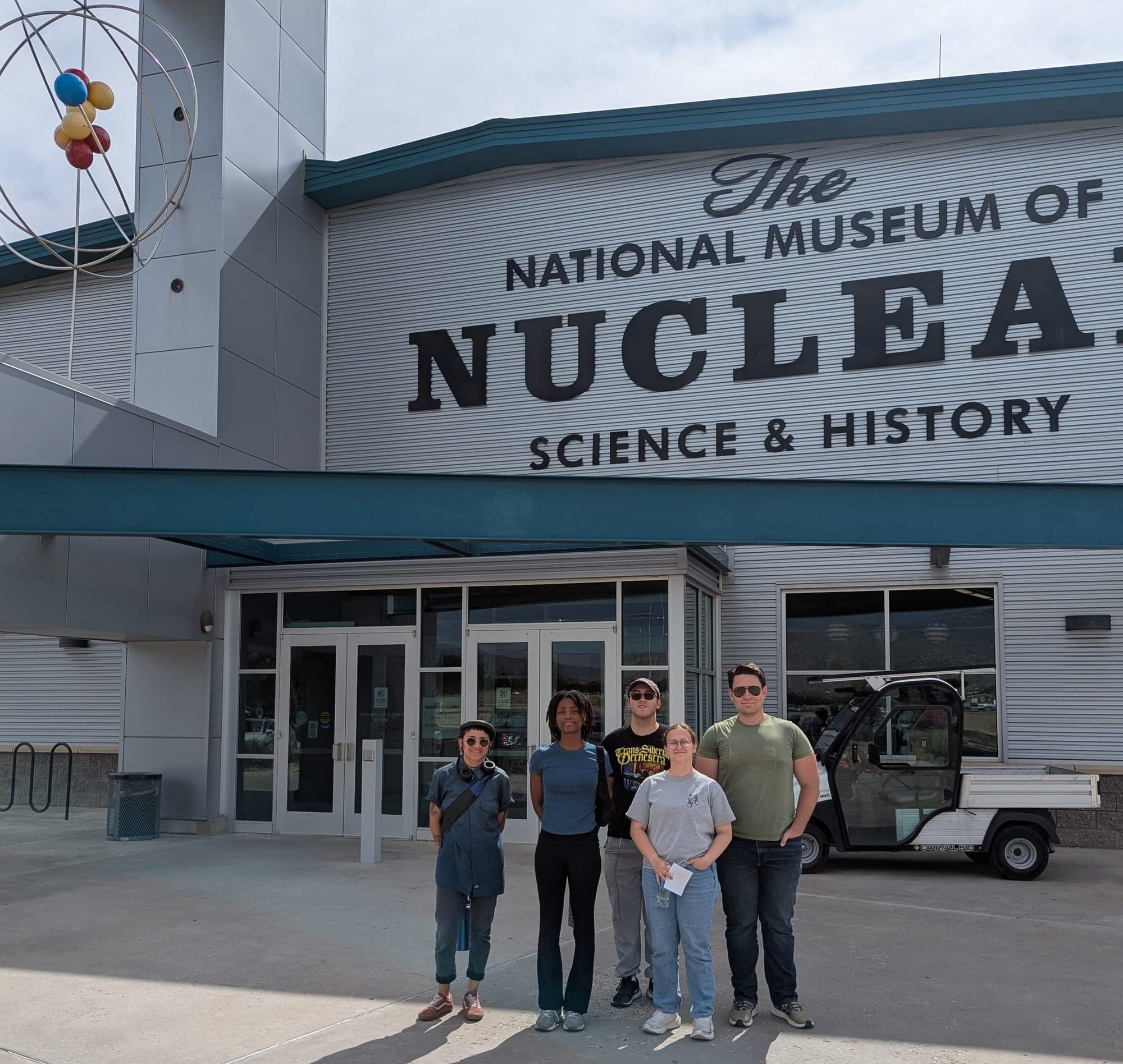 Five students attending New Mexico State University's NuChemE Pipeline summer initiative are standing in front of the National Museum of Nuclear Science & History.