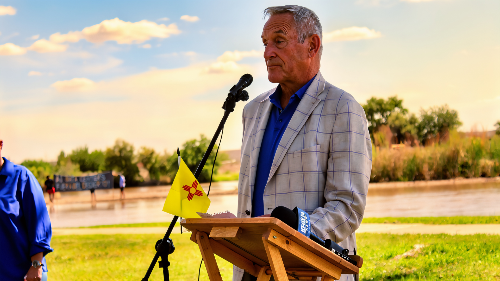 Sen. Bill Soules speaks at a microphone near the Rio Grande during a press conference at La Llorona Park.