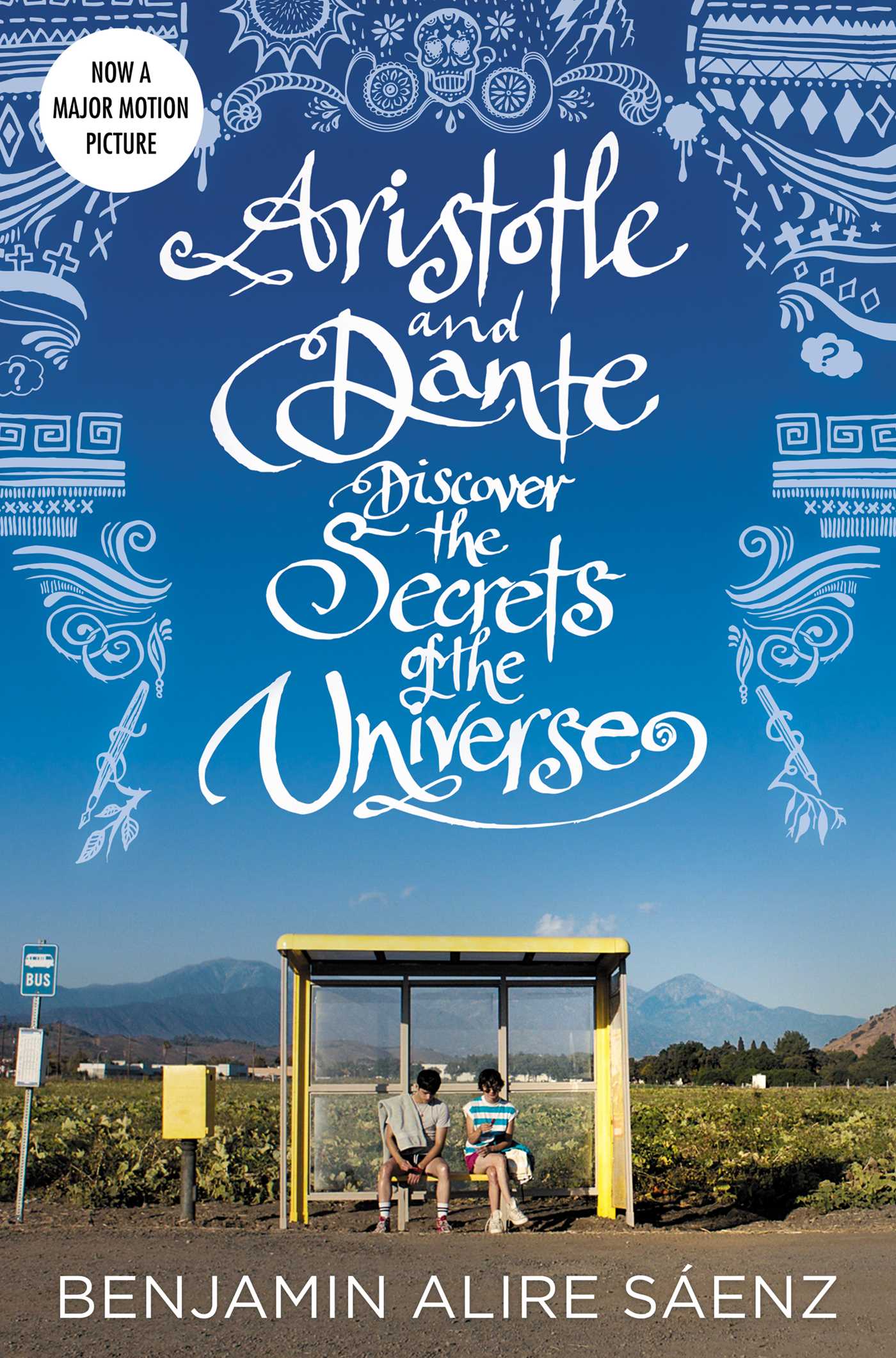 Book cover for Benjamin Alire Sáenz’s Aristotle and Dante Discover the Secrets of the Universe, showing two boys seated at a rural bus stop beneath white illustrated lettering on a blue sky.