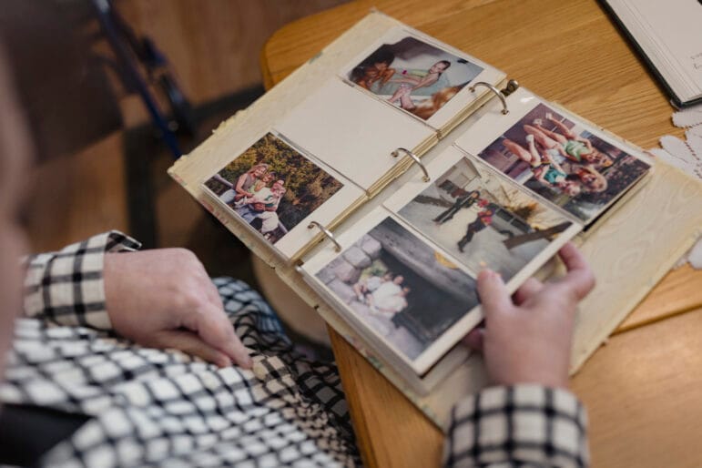 Tracie Koslik looks through an open family photo album on a table at her Albuquerque home.