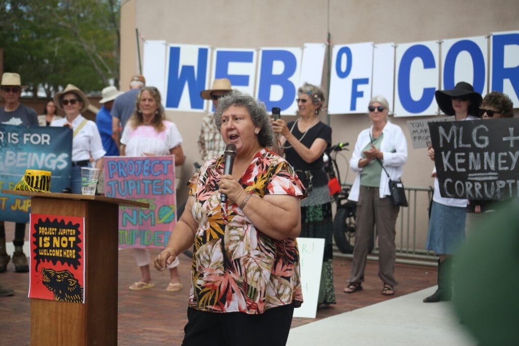 Irene Rodriguez speaks into a microphone during an Aug. 21 protest against Project Jupiter outside the New Mexico Environment Department in Santa Fe.