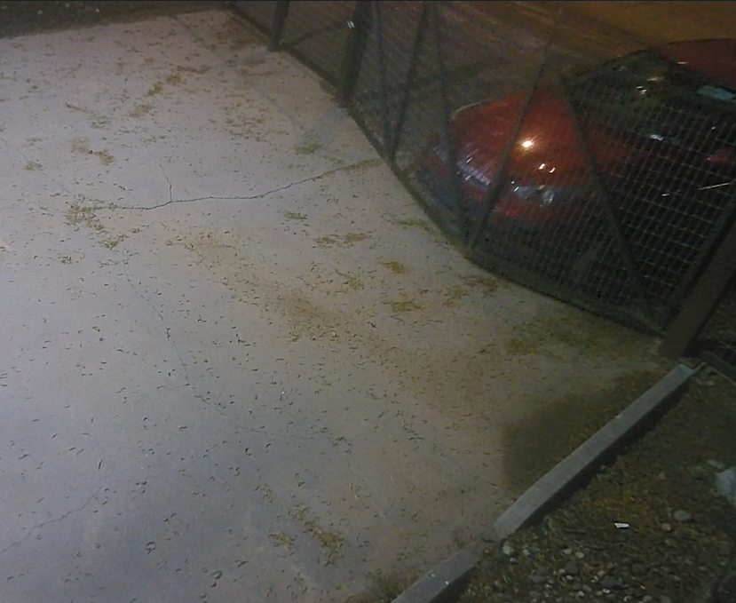 Surveillance image showing a red Kia Forte pushing through a security gate at Strykers Shooting World in Las Cruces.