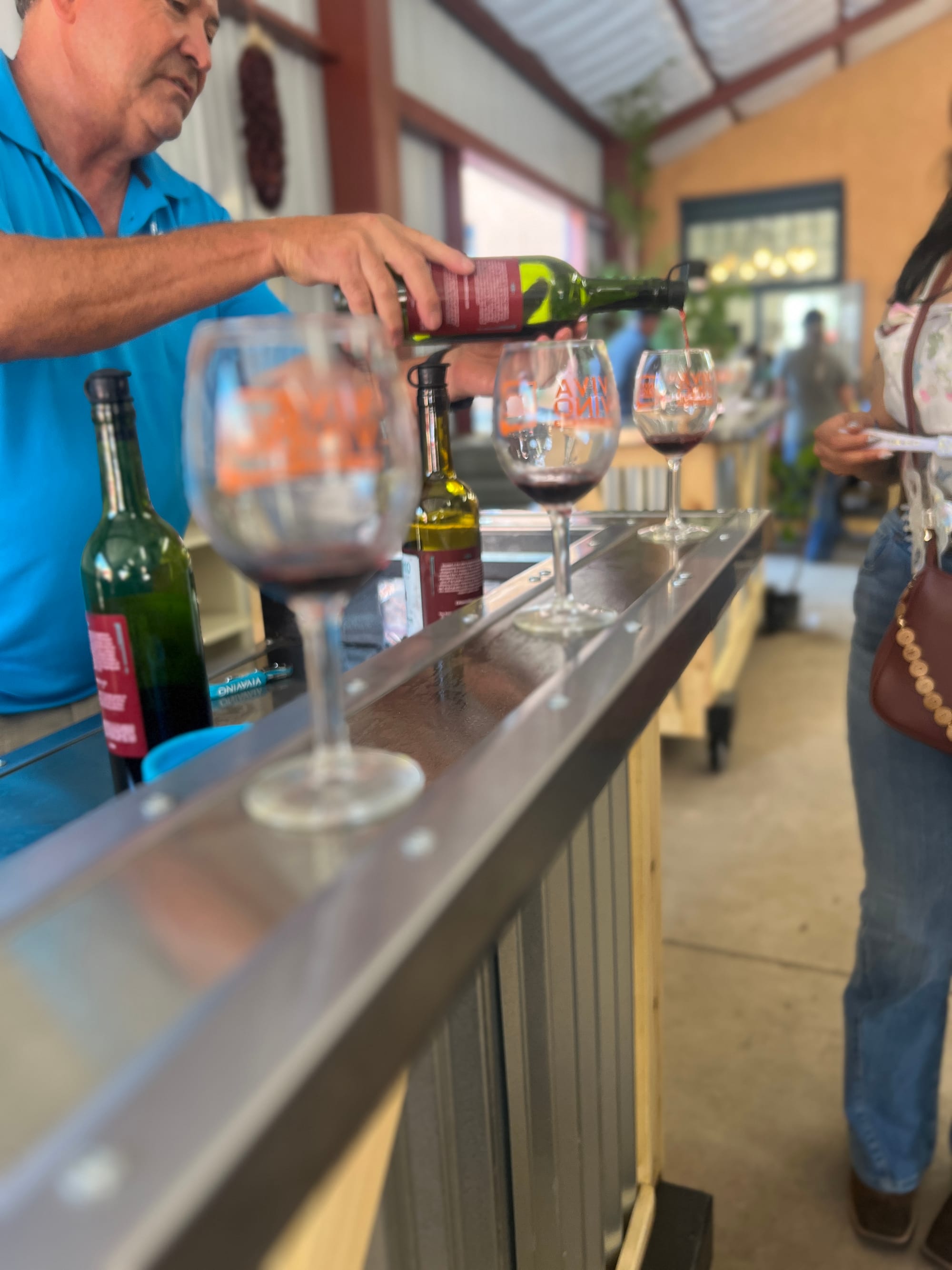A vendor pours red wine into tasting glasses during a New Mexico State Fair happy hour.