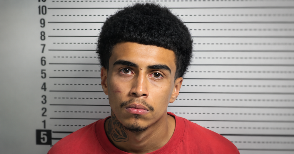 Jerimiah Angel Castillo Zubiran, 18, faces the camera in a booking photo against a height chart.