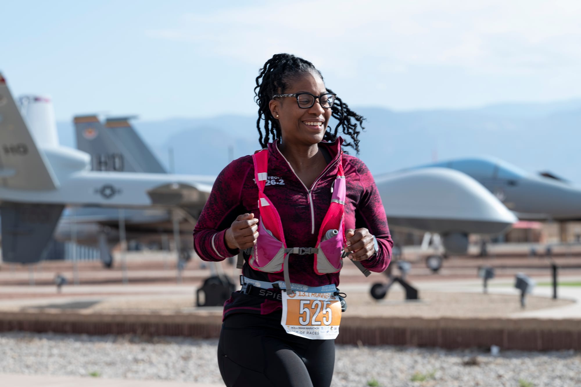 A runner wearing bib 525 passes MQ-9 remotely piloted aircraft during a previous Ace of Races event at Holloman Air Force Base.