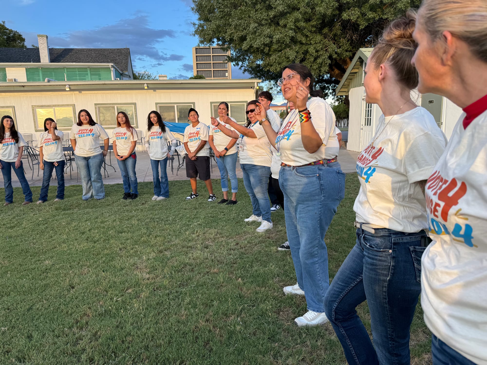 Vote for Change volunteers wearing Amendment 4 shirts stand in a semicircle outdoors during a Las Cruces canvassing event.