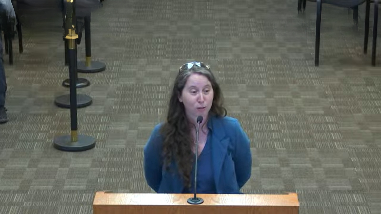 Cruces Creatives Executive Director Lea Wise-Surguy, wearing a blue blazer, speaks at a podium during the Oct. 13, 2026, County Commission meeting.