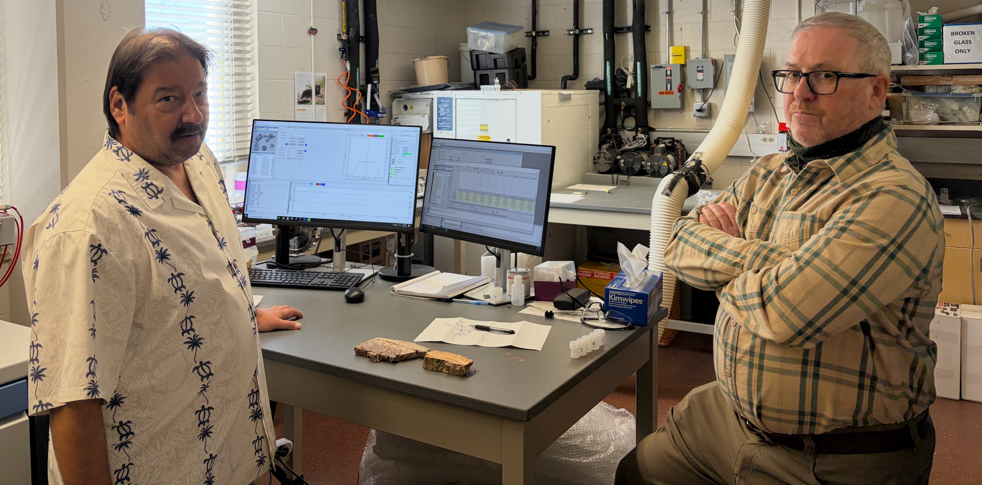 NMSU geology professor Frank Ramos, left, and geological sciences department head Eric Ferré stand beside rock samples and computer monitors in a laboratory.