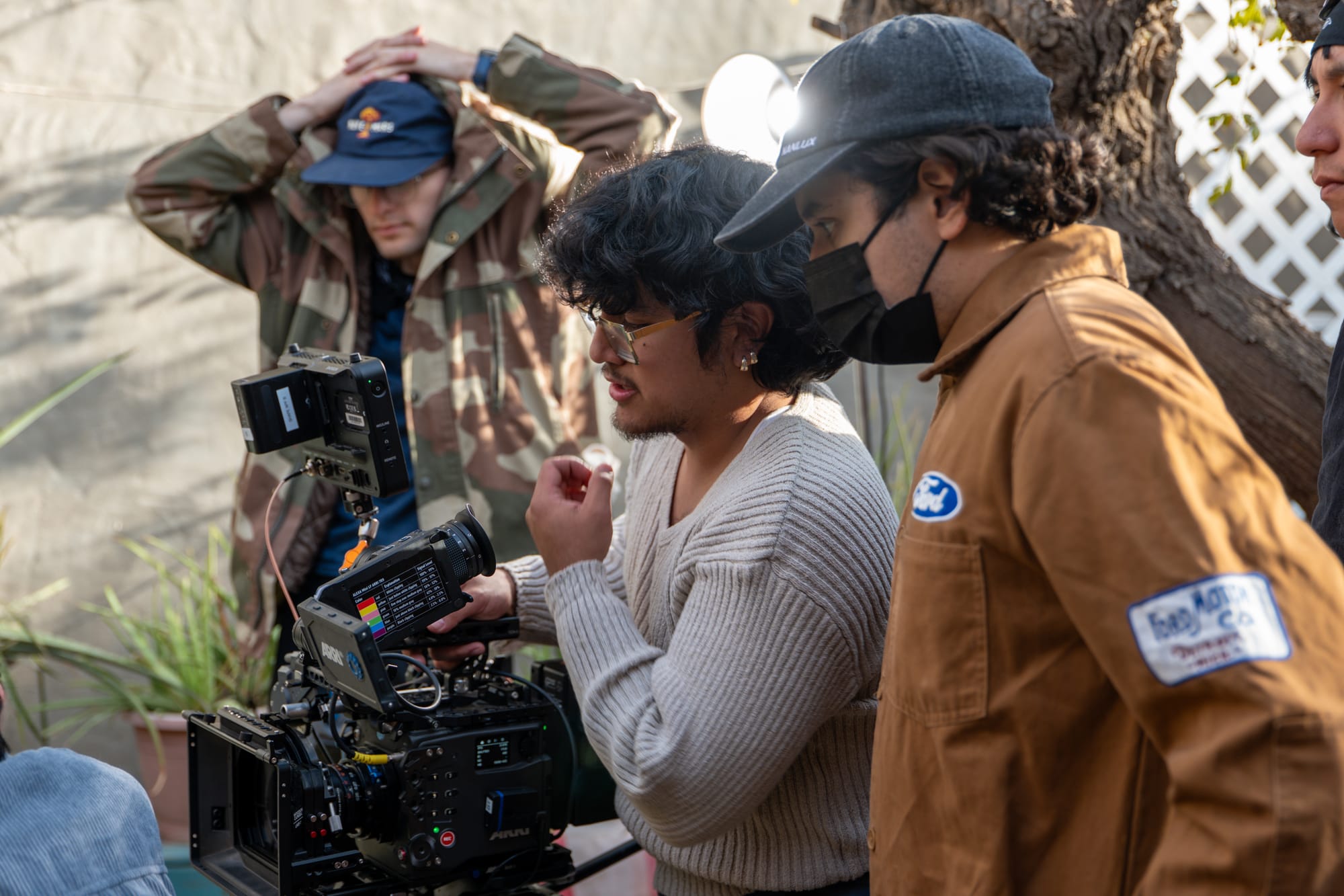 Aldo Morales and crew members review a camera setup while filming “La Carne Asada.”
