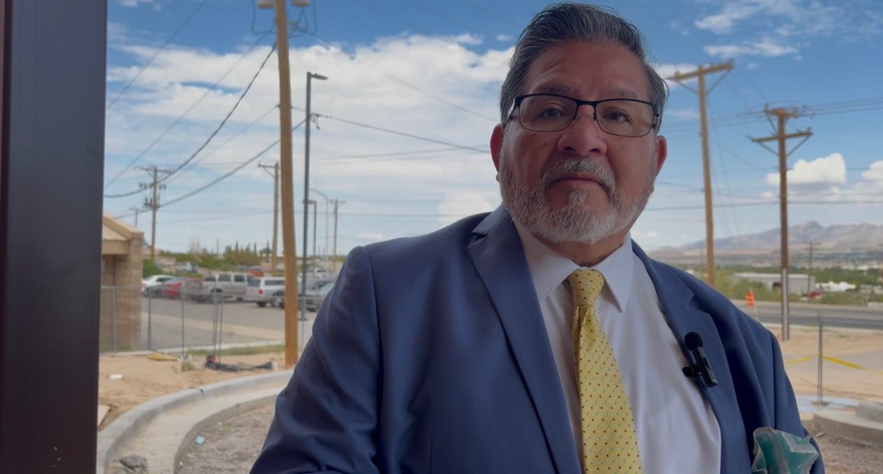 Casa de Peregrinos Executive Director Lorenzo Alba Jr., wearing glasses, a blue suit and yellow tie, stands outside the new Sunland Park food pantry under construction.