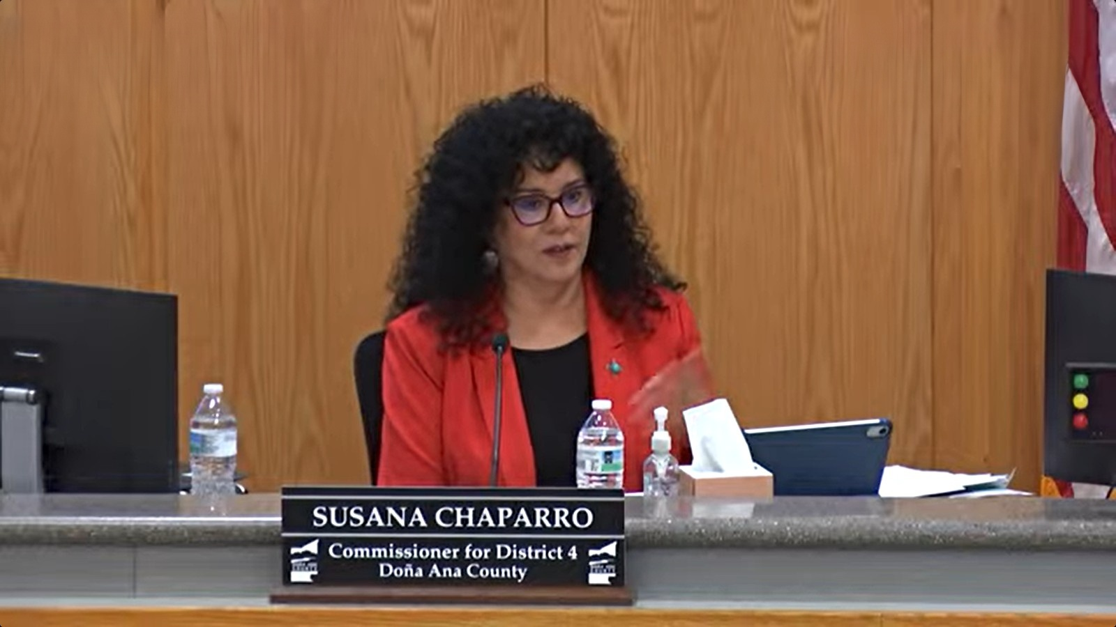 Doña Ana County Commissioner Susana Chaparro, wearing a red blazer and glasses, speaks from the dais during the Oct. 13, 2026, meeting.