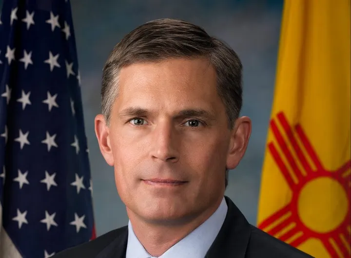 Official portrait of U.S. Sen. Martin Heinrich, with the American flag and New Mexico state flag in the background.