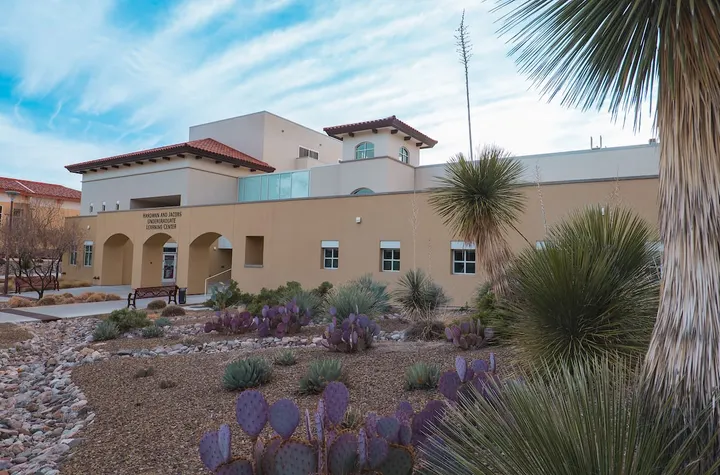 Exterior of the Hardman and Jacobs Undergraduate Learning Center at New Mexico State University, with desert landscaping featuring cacti and yucca plants in the foreground.