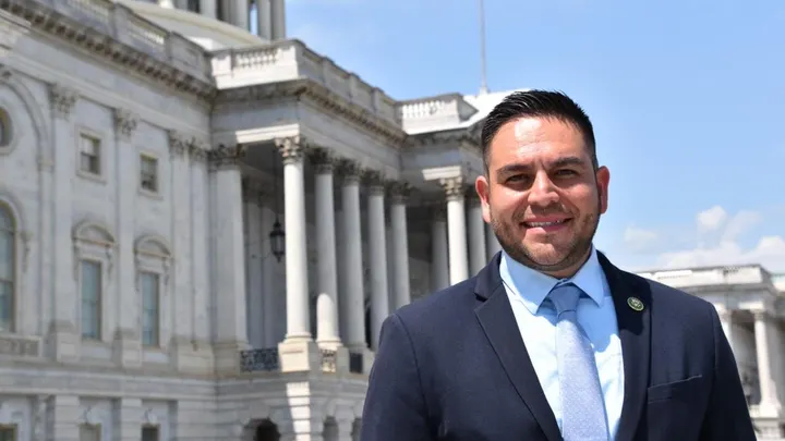 U.S. Rep. Gabe Vasquez stands outside the U.S. Capitol building on a sunny day, wearing a suit and tie.