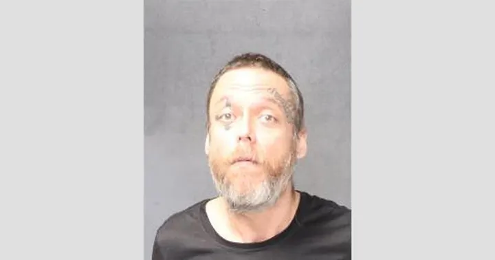 Mugshot of Jeffrey Ramon Diaz, a middle-aged man with facial tattoos, short dark hair, and a graying beard, wearing a black shirt, against a gray background.