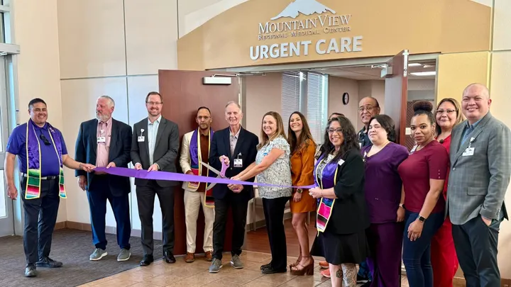 A group of MountainView Regional Medical Center staff and community members cut a purple ribbon to celebrate the opening of MountainView Urgent Care at Lohman Avenue.