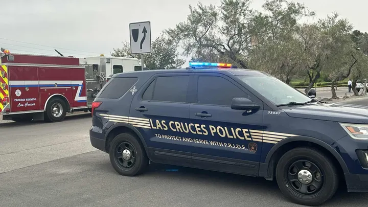 A Las Cruces Police Department SUV blocks a road near Salopek Park as an LCPD officer and a fire engine from Las Cruces Fire Department are seen in the background at an active scene.