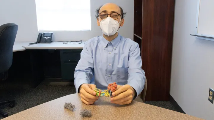 Matthew Guberman-Pfeffer, assistant professor at New Mexico State University, holds a tactile sheet to the light, showing raised patterns that help blind students study molecular science.