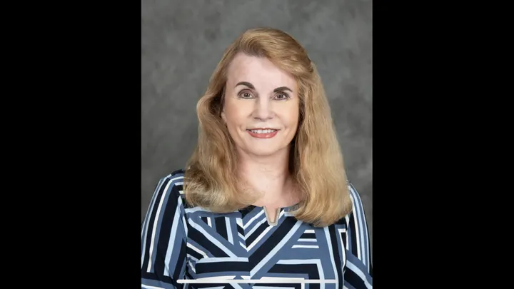 Melanie Kenderdine, New Mexico’s secretary of Energy, Minerals and Natural Resources, poses for an official portrait against a gray backdrop.
