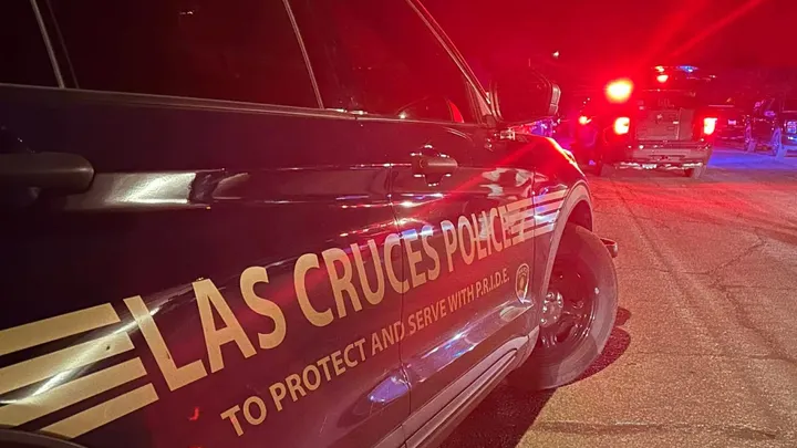 Las Cruces police vehicles with emergency lights on at night during a response scene
