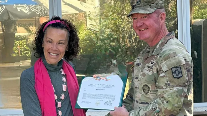 Marci Dickerson receives the New Mexico Medal of Merit from Brig. Gen. Nathaniel Carper during a ceremony in Las Cruces