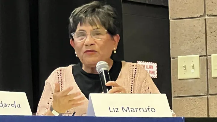 Liz Marrufo speaks into a microphone during a RECA forum at Doña Ana Community College in Las Cruces.