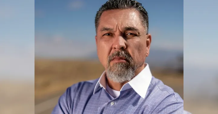 Greg Cunningham poses outdoors in a campaign-style portrait wearing a button-down shirt.