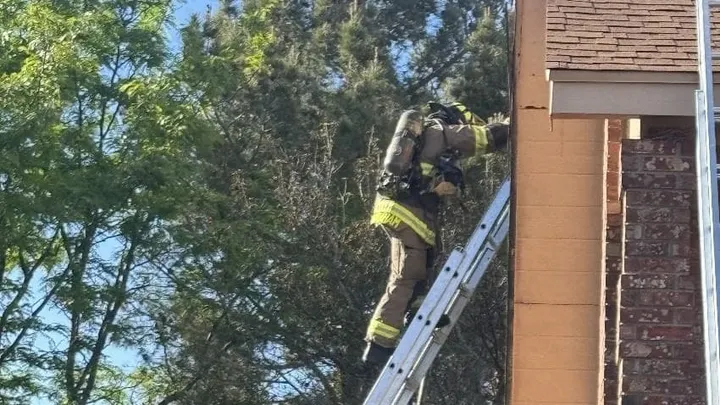 Firefighters working outside a two-story home during a structure fire response on Stagecoach Drive in Las Cruces