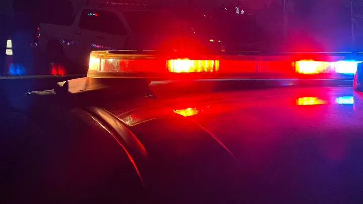 Police vehicle lights flashing red and blue during a nighttime response scene
