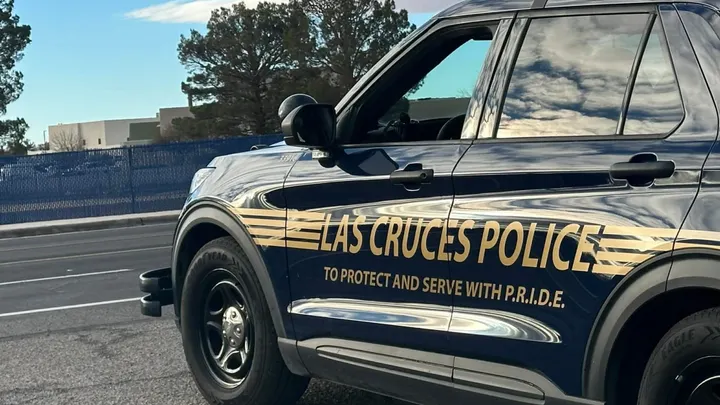 Las Cruces Police vehicle parked along a city street with department markings visible on the side.