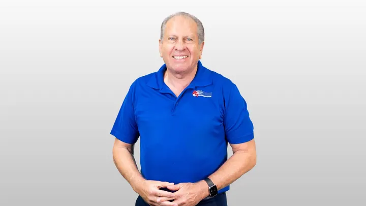 Mesilla Valley Transportation founder Royal Jones poses for a portrait in a blue company shirt.