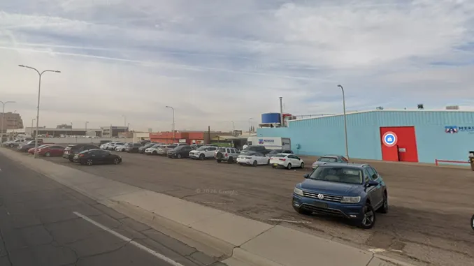 City parking lot at North Campo Street and East Hadley Avenue in Las Cruces, with cars parked beside a blue building.