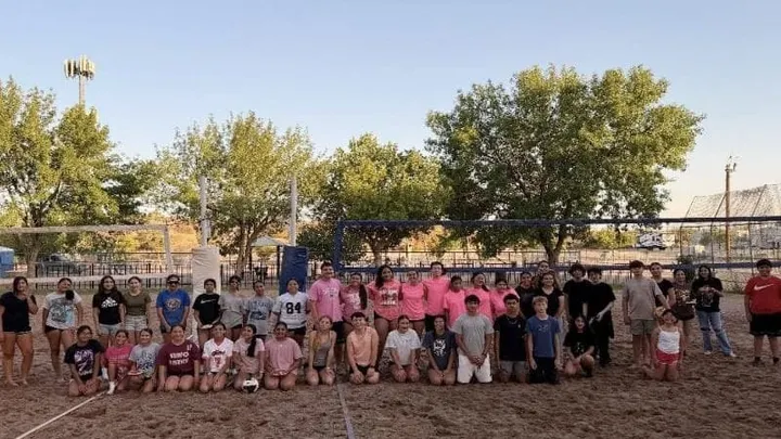 Teens pose for a group photo on the sand volleyball courts at Meerscheidt Recreation Center.