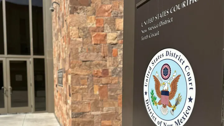 Sign for the U.S. District Court in Las Cruces outside a courthouse entrance.