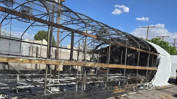Fire-damaged greenhouse with blackened framing and burned covering on Nevada Avenue in Las Cruces.
