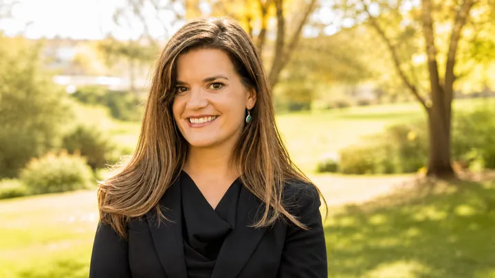 New Mexico Secretary of State Maggie Toulouse Oliver smiles for an outdoor portrait.