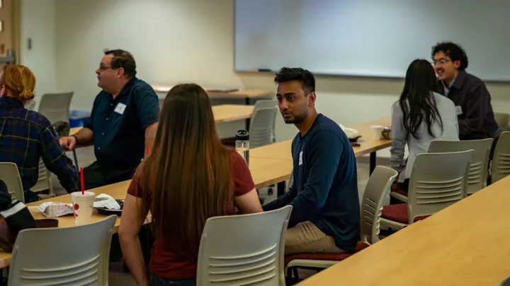 NMSU students sit in small groups during an entrepreneurship program gathering.