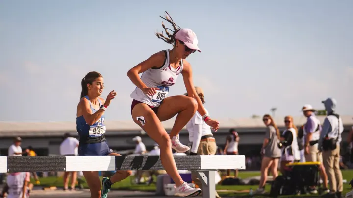 Nia Allison clears a steeplechase barrier during an NM State women’s track and field competition.