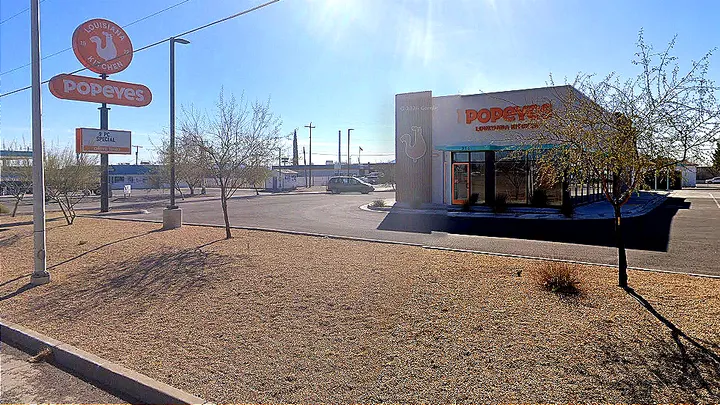 A Google Street View image shows a Popeyes restaurant in Deming with its sign, parking lot and building visible in bright sunlight.