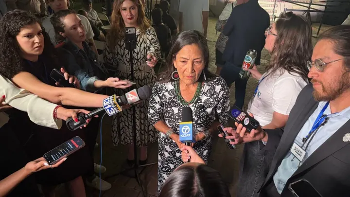 Deb Haaland speaks to a group of reporters holding microphones and recording devices after winning the Democratic nomination for New Mexico governor.
