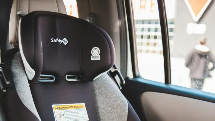 A black and gray child safety seat secured in the back seat of a vehicle.
