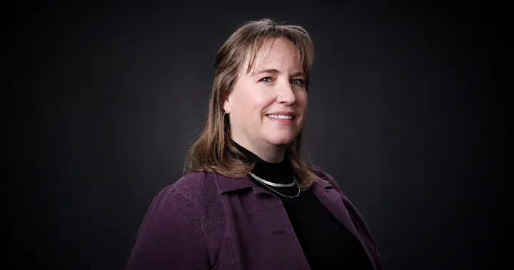 Las Cruces Finance Director Lesley Doyle poses for a studio portrait against a dark background.