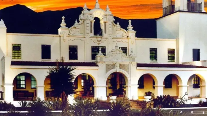 Federal Correctional Institution La Tuna is shown in Anthony, Texas, with Spanish mission-style architecture and mountains in the background.