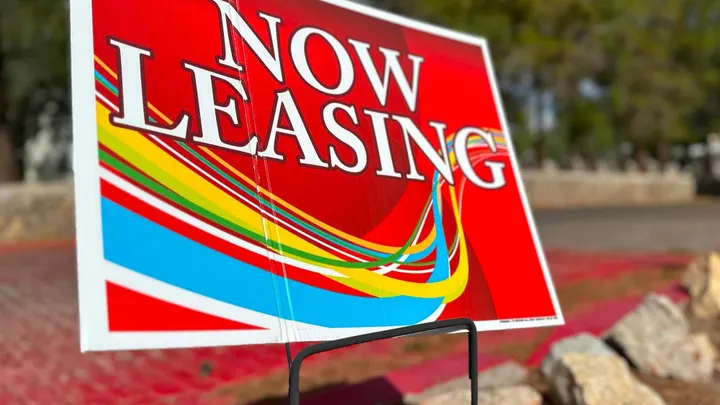 Red “Now Leasing” sign displayed outside a rental property as Las Cruces police warn about online rental scams.