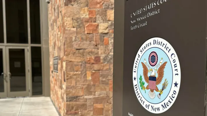 A sign bearing the seal of the U.S. District Court for the District of New Mexico stands outside the federal courthouse in Las Cruces.