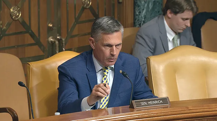 U.S. Sen. Martin Heinrich speaks into a microphone during a Senate committee hearing, seated behind a nameplate bearing his name.