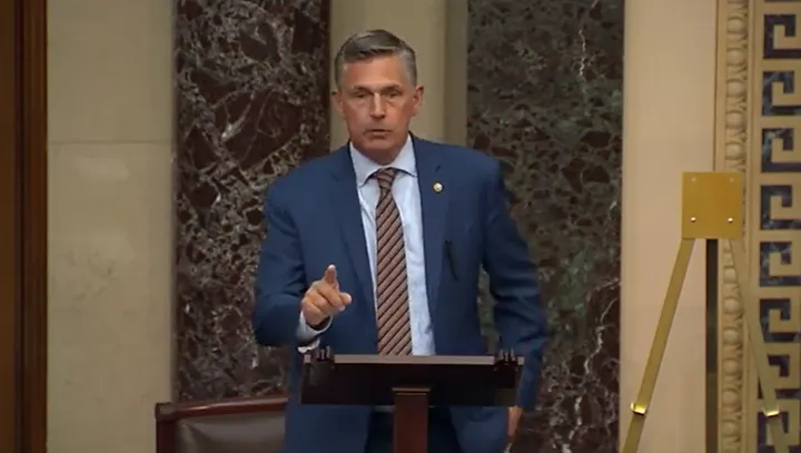 U.S. Sen. Martin Heinrich speaks from a lectern on the Senate floor, gesturing with one hand.